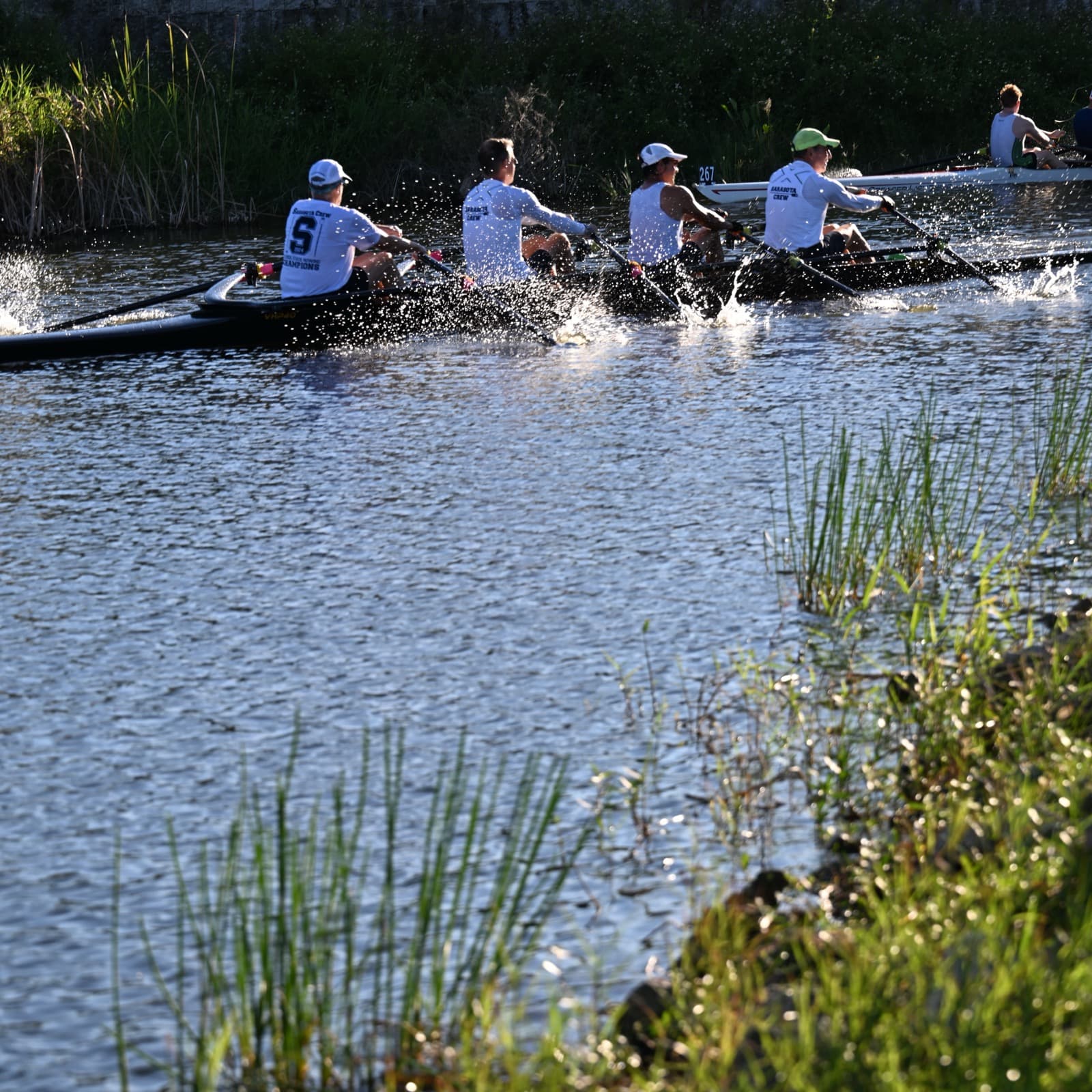 Rowing crew driving through the water at sunrise